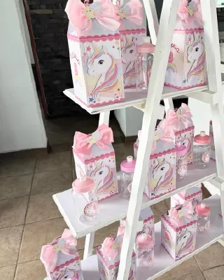 Cajas de recuerdo personalizadas con moño rosa en una repisa escalera blanca